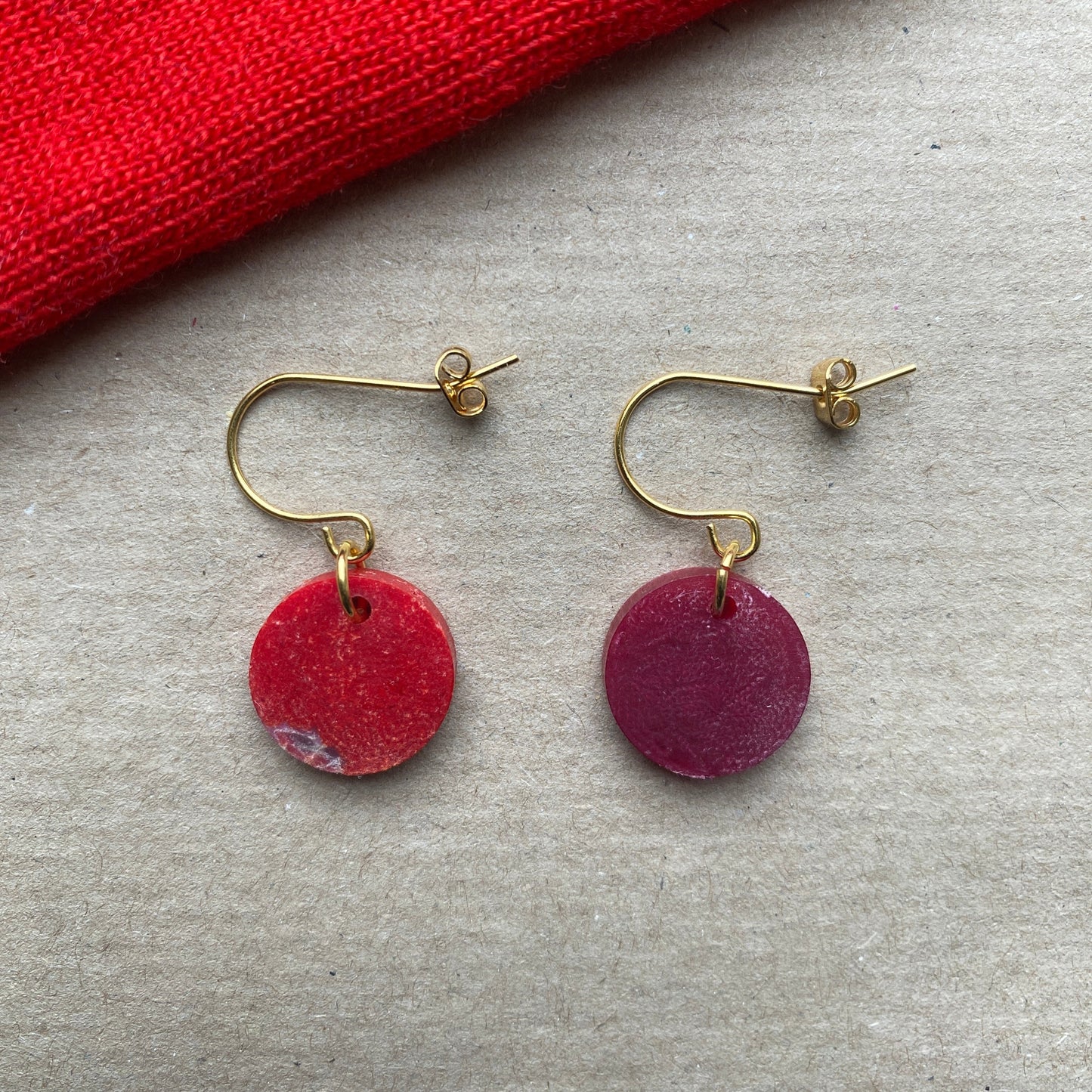 Handmade round dangle earrings crafted from upcycled Fabreco in deep red and crimson hues with gold-plated hooks, sustainable fashion accessory.